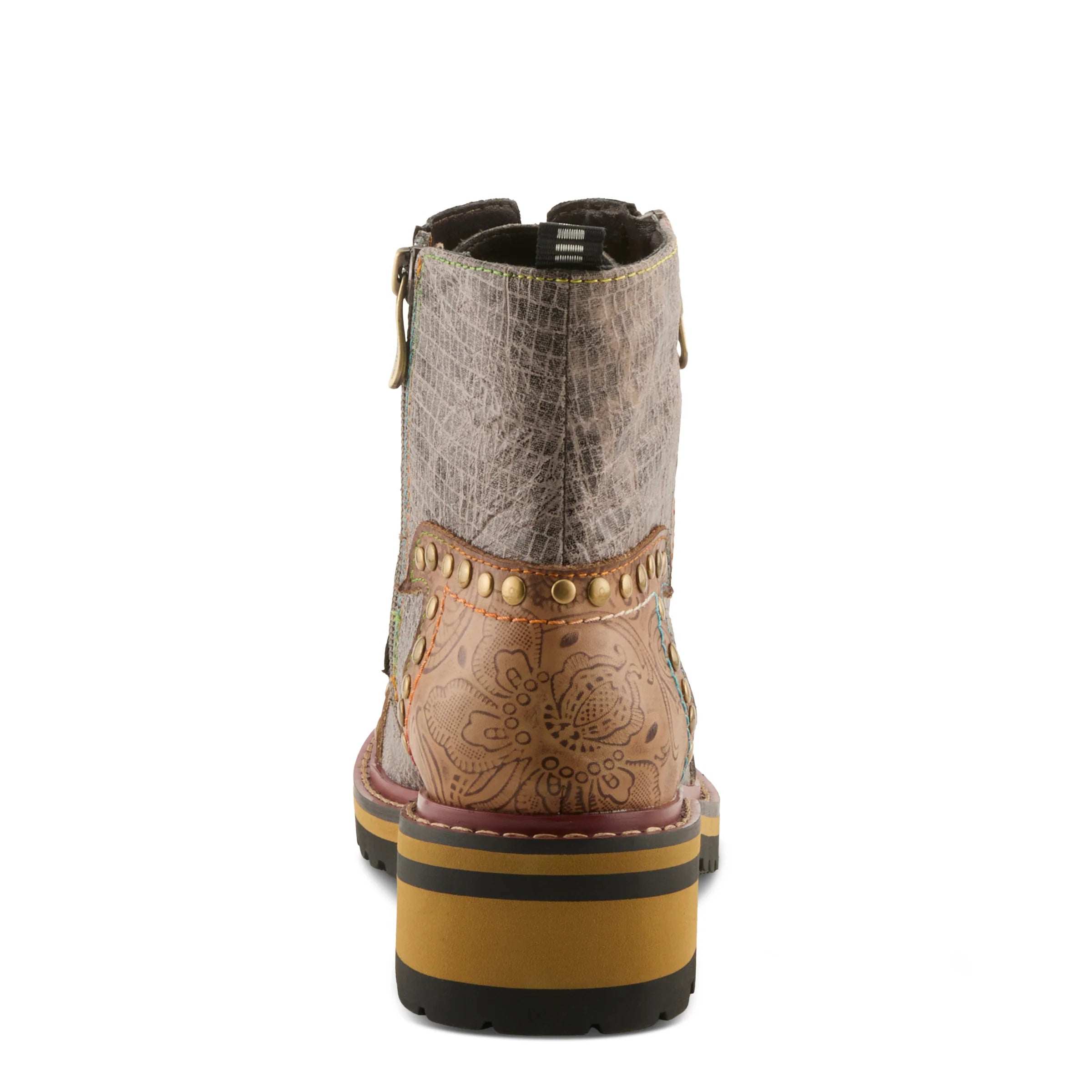 A single ankle boot shown from the back on a white background, featuring a textured taupe upper, floral tooled tan leather heel, gold-tone studs, and a stacked yellow, black, and brown sole.