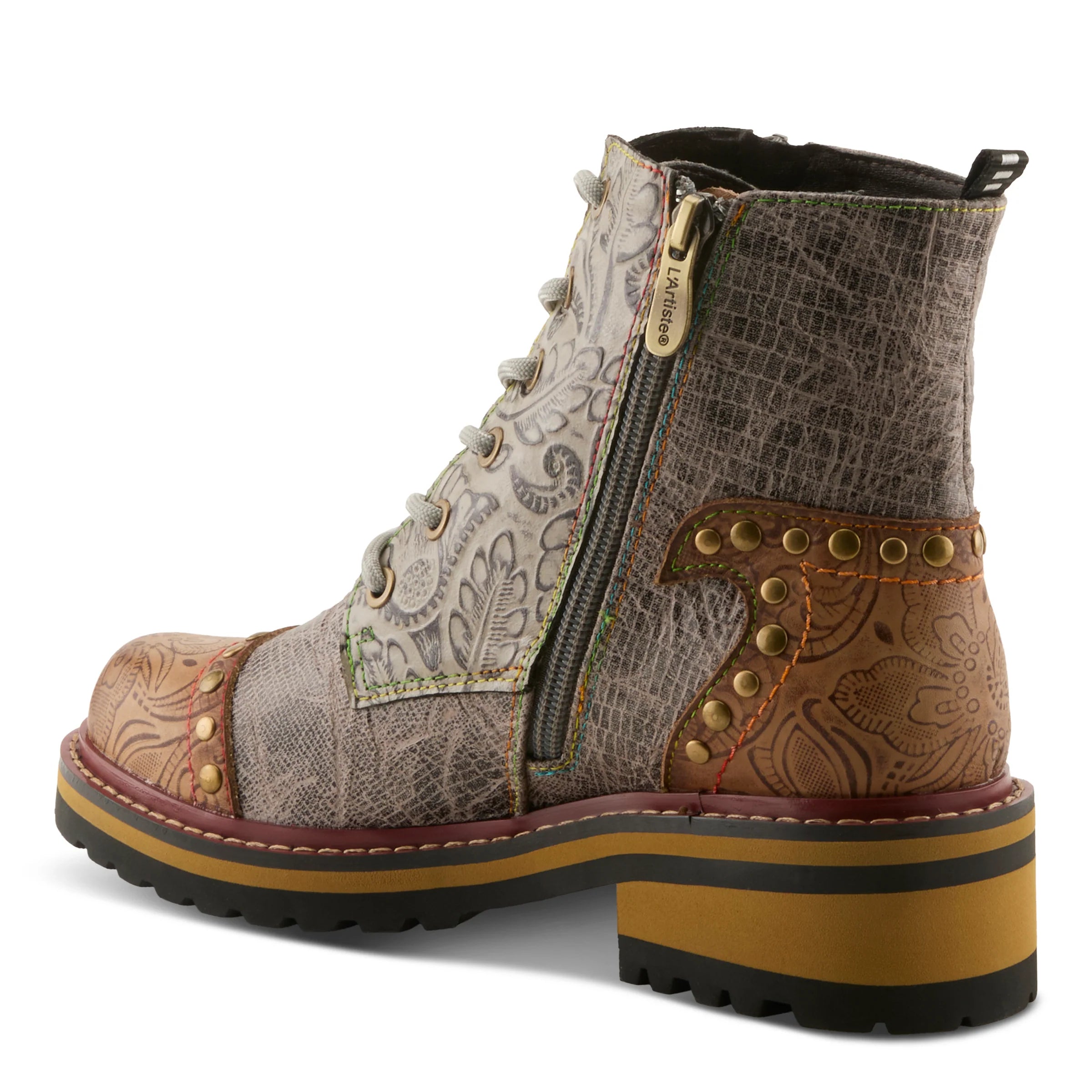 A western-style ankle boot featuring a mix of textured materials including embossed snakeskin, tooled leather, and paisley-patterned fabric. The boot has a side zipper, lace-up front, and a chunky platform heel with a yellow and black sole, shown against a plain white background.