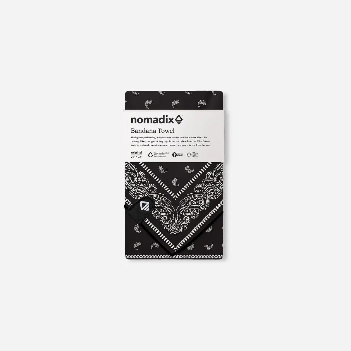 A packaged Nomadix Bandana Towel, featuring a black and white paisley patterned towel with its white paper label wrapper.