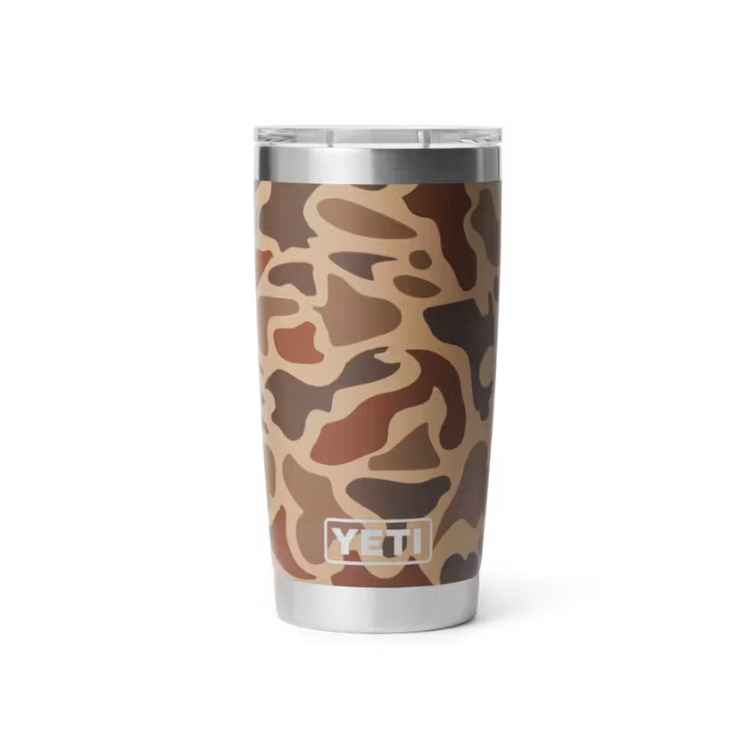 A YETI insulated travel tumbler with a brown and beige camouflage pattern, featuring a clear lid and stainless steel base, shown on a white background.