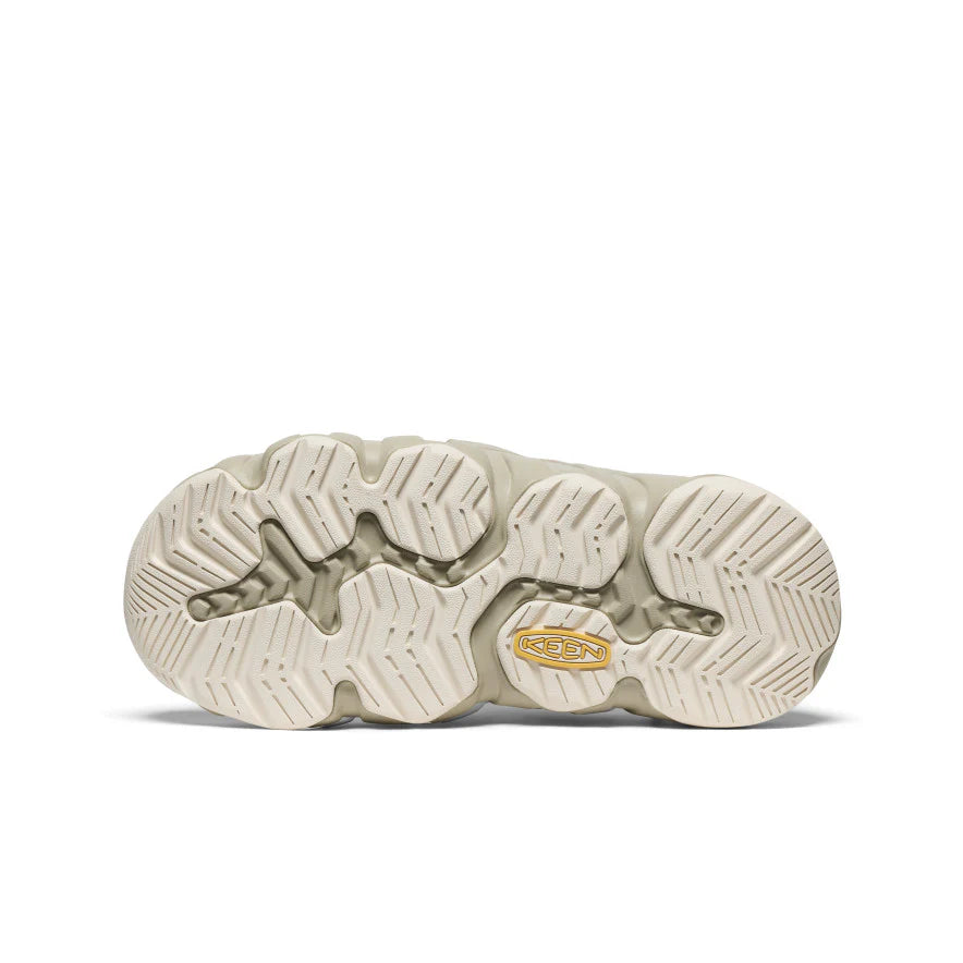 Close-up of a beige shoe sole with brand logo on a white background