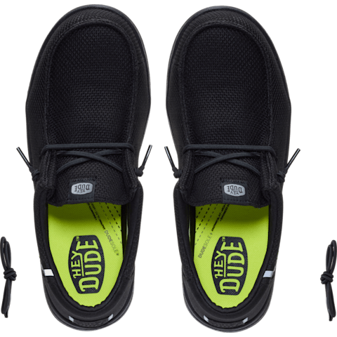 Black shoes with neon green sole displaying 'The Dude' branding on a clear background