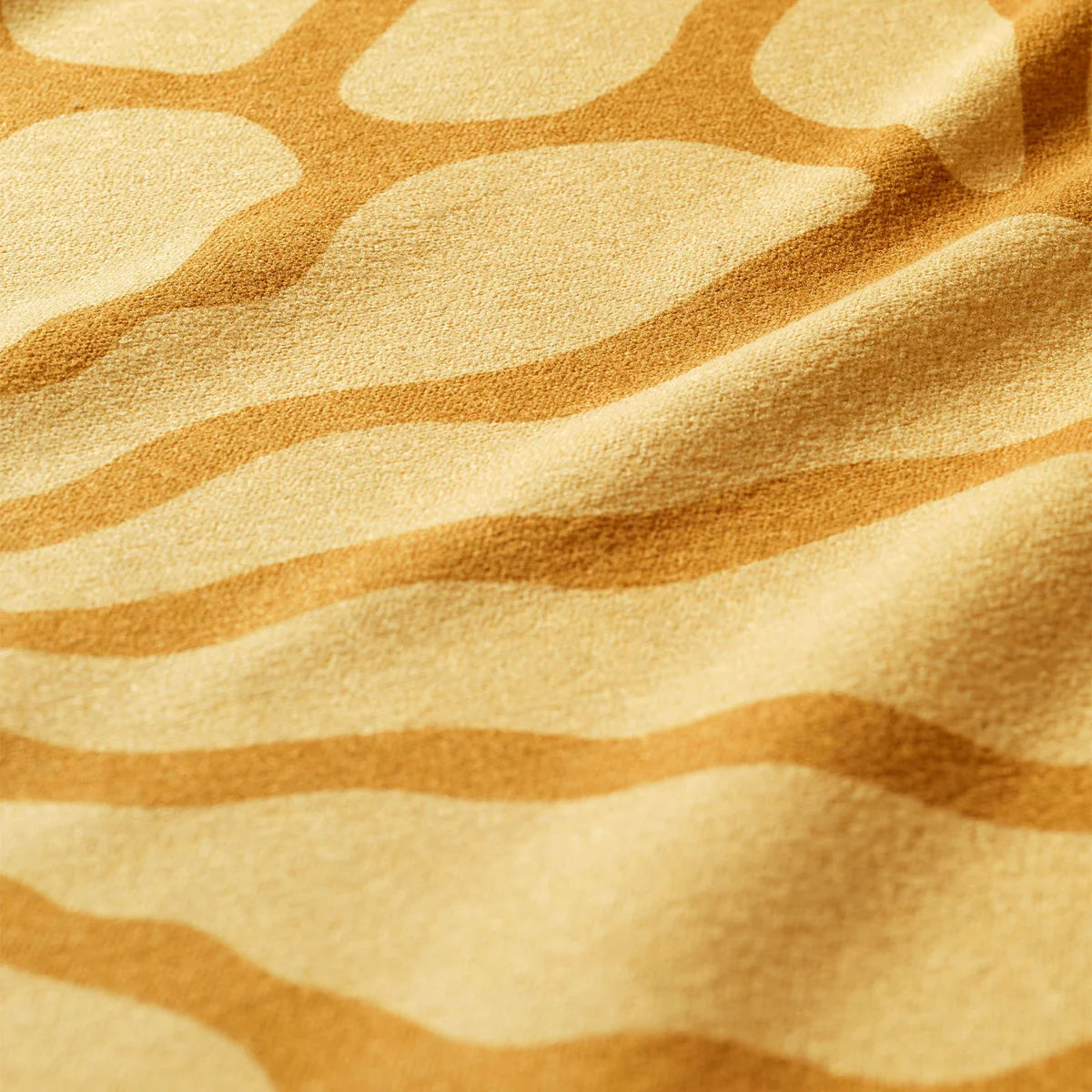 Close-up of a textured fabric with wavy brown patterns on a beige background