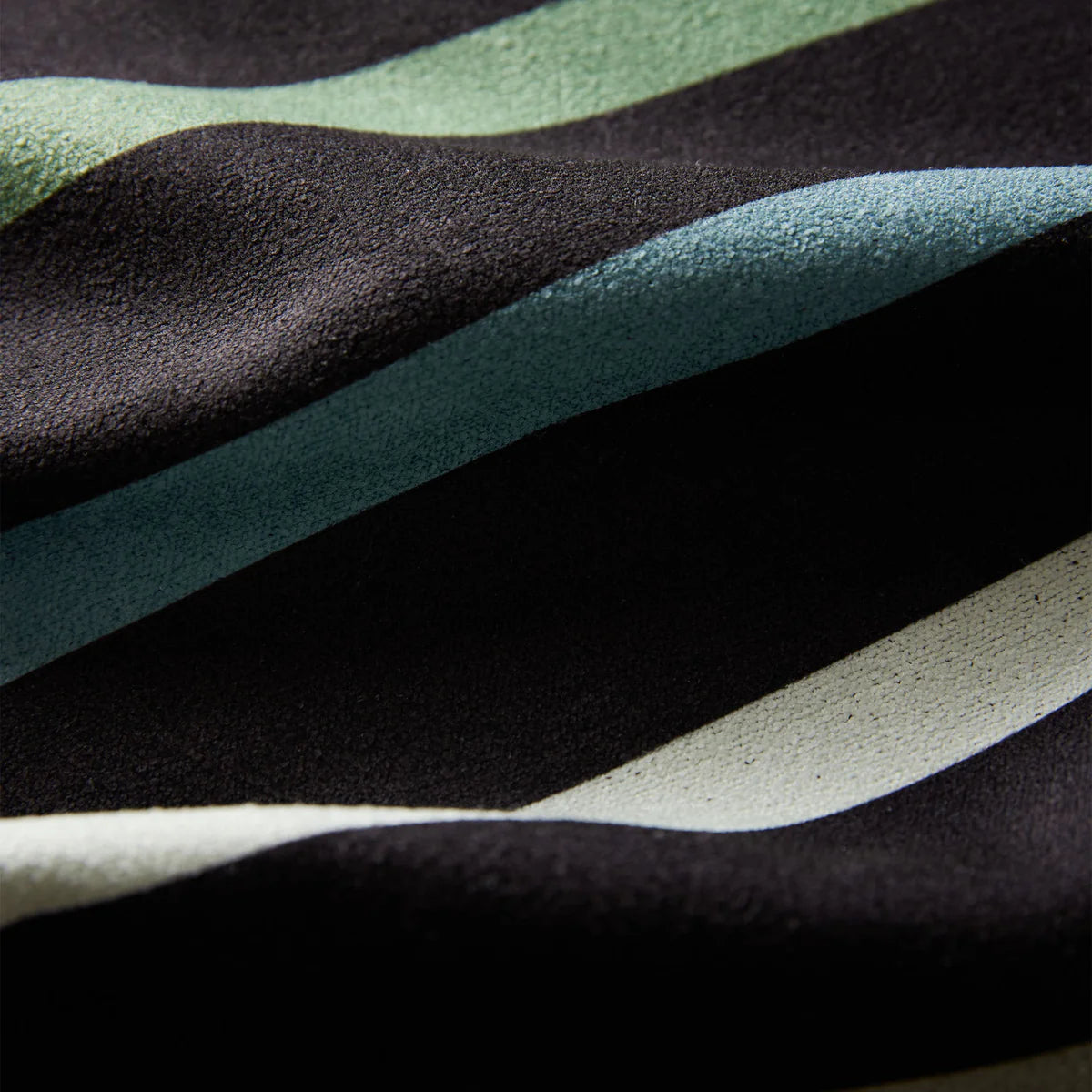 Close-up of fabric with black, green, and white horizontal stripes.