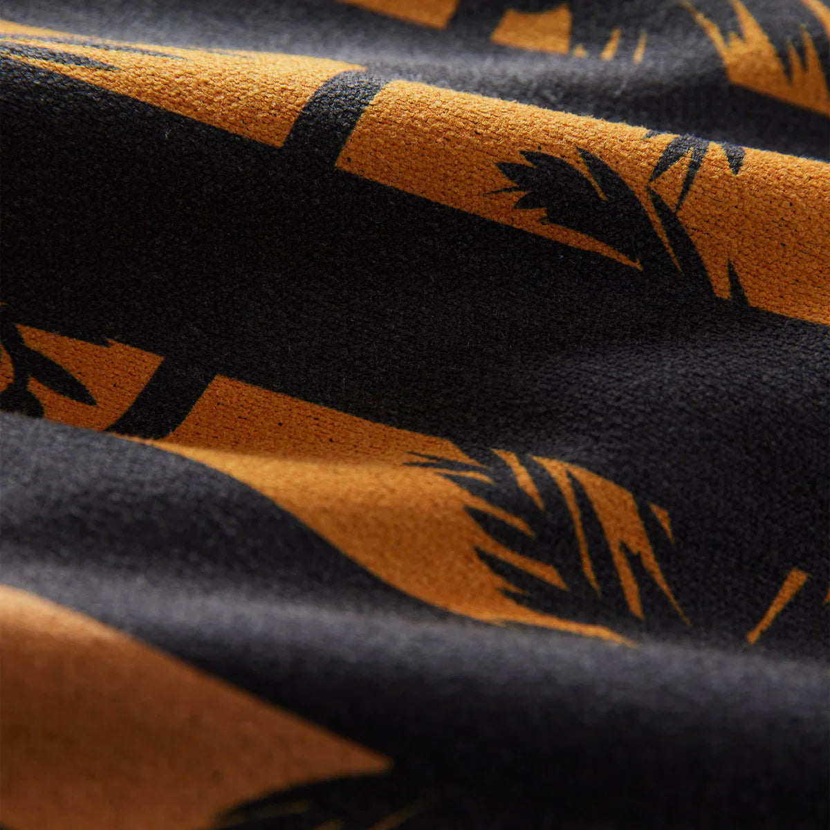 Close-up of black and orange fabric with leaf pattern