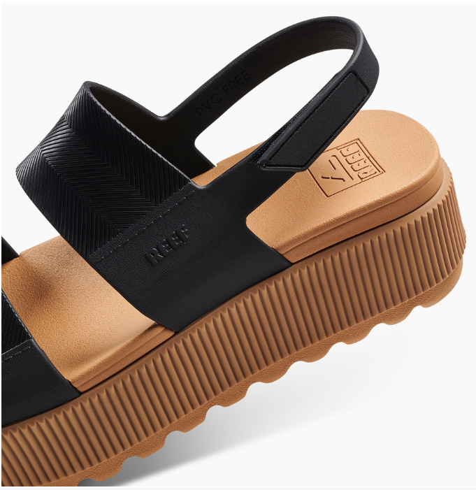 Black and brown sandal with a visible brand logo on a light gray background