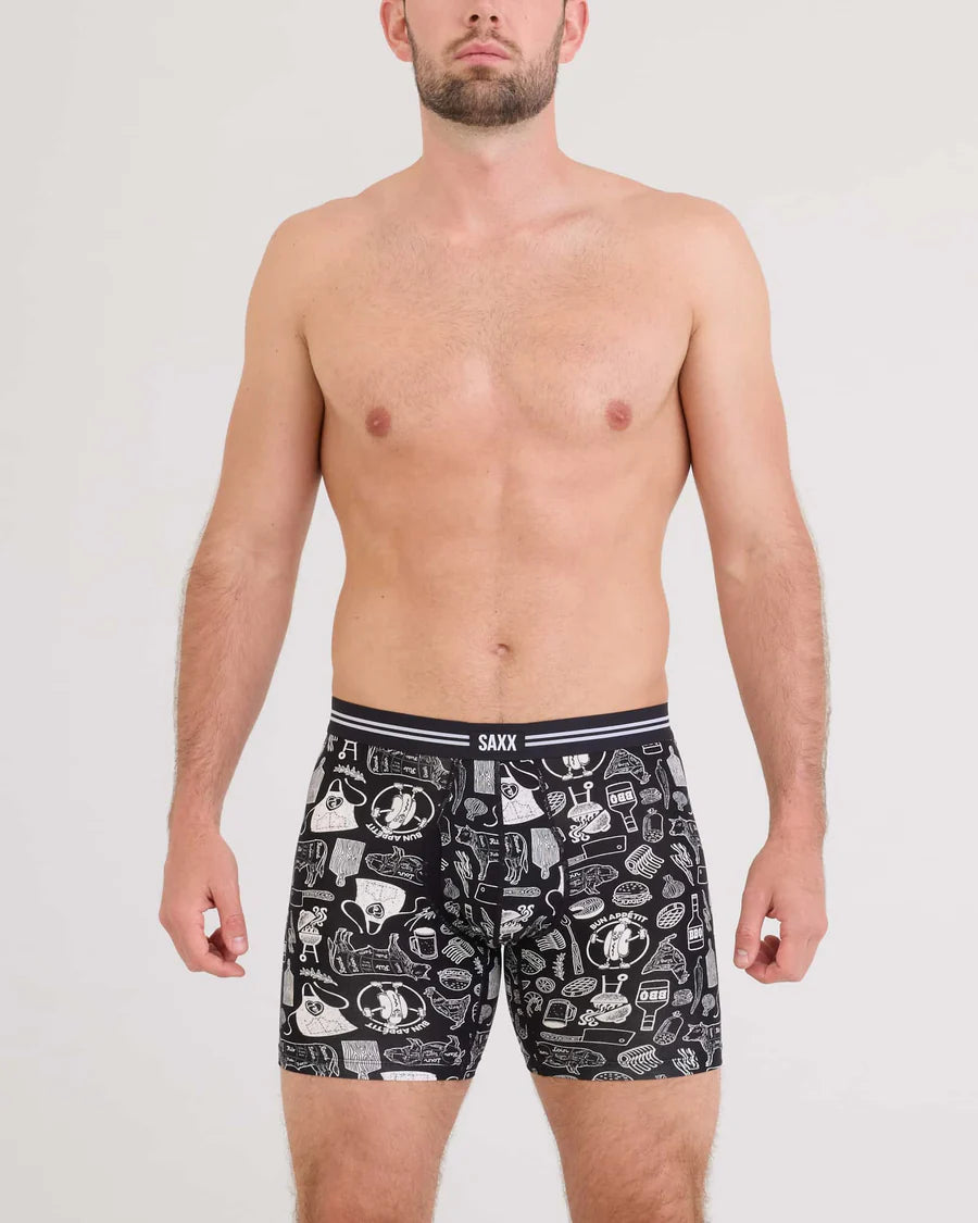 Man wearing black patterned boxer briefs on a white background
