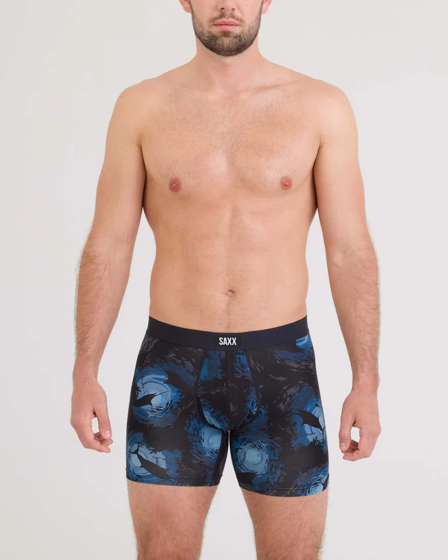 Man wearing blue and black patterned SAXX underwear on a white background