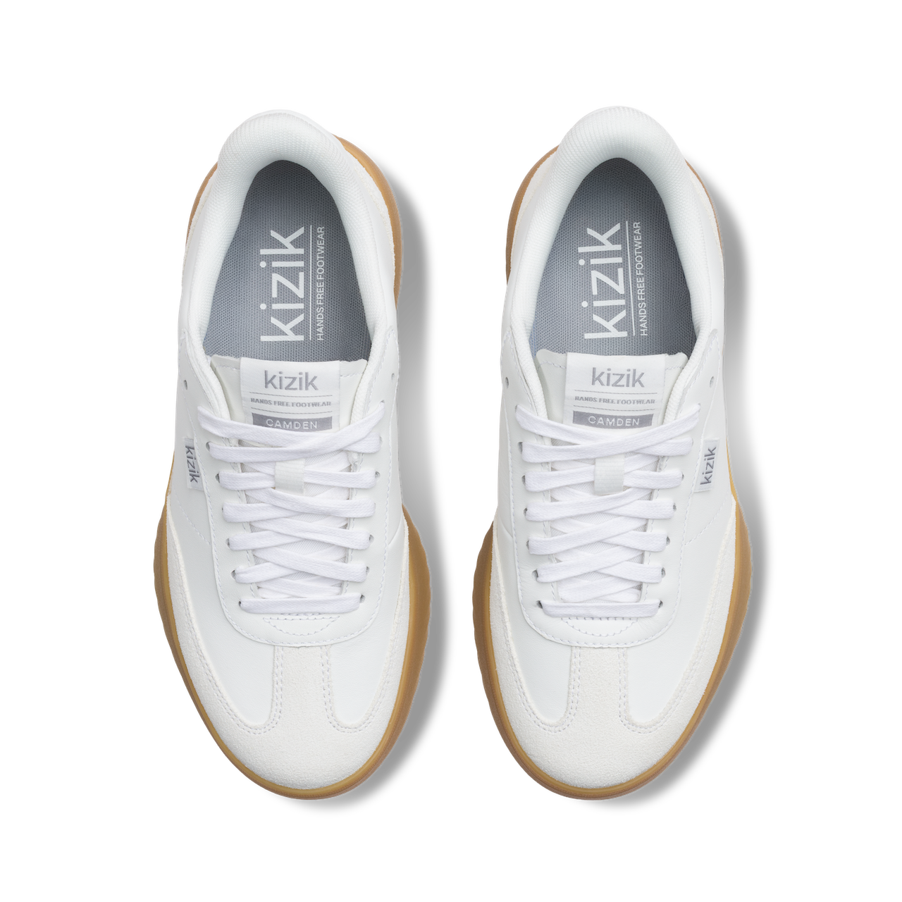 White sneakers with brown soles and visible 'kizik' branding on a white background
