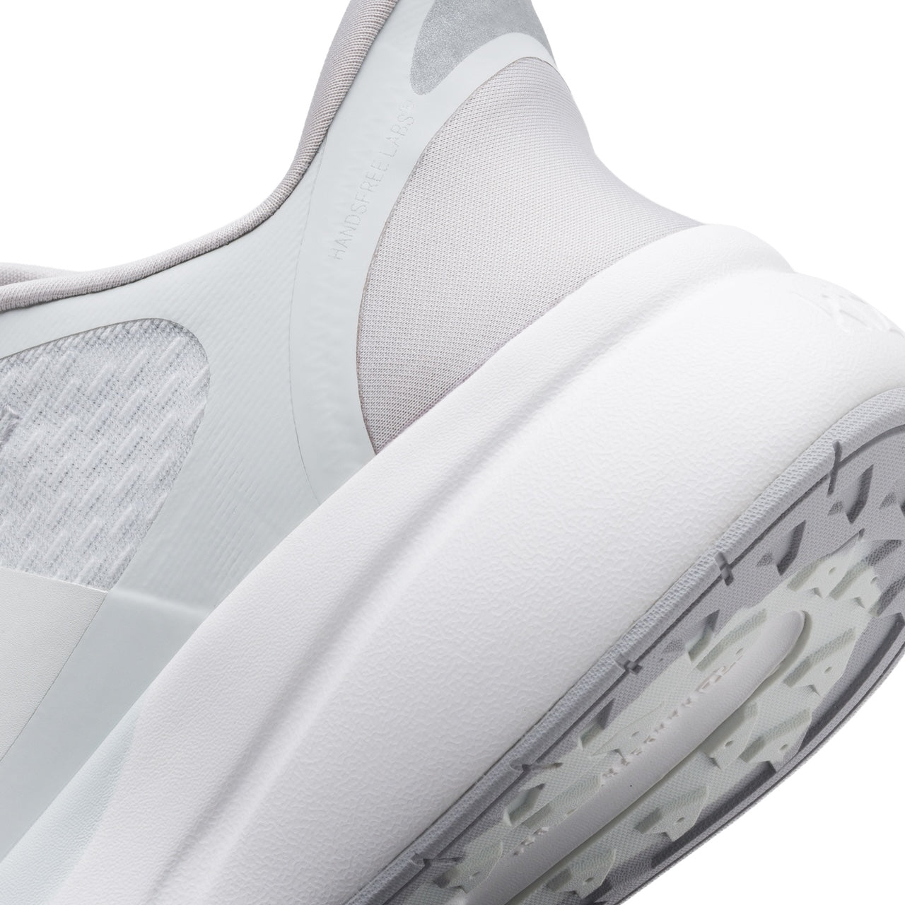Close-up of a white athletic shoe with mesh design on a white background