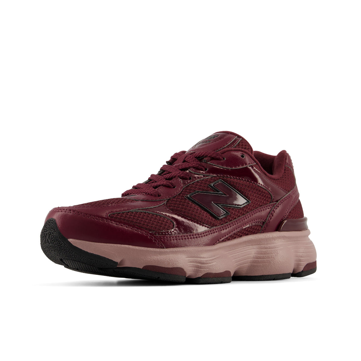 A New Balance running shoe in burgundy and dusty rose, featuring a chunky layered sole and glossy synthetic overlays, shown from a side profile on a white background.