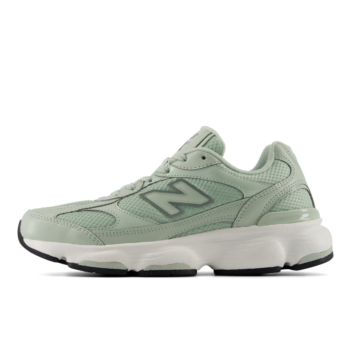 A New Balance sneaker in a light sage green colorway, featuring a mesh and leather upper, a large 'N' logo on the side, and a chunky white midsole with black outsole details, shown against a plain white background.