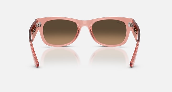 Pink sunglasses with brown gradient lenses on a white background