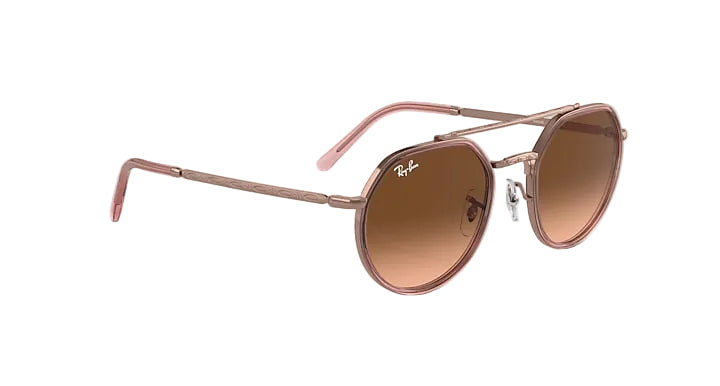 Rose gold sunglasses with brown lenses on a white background