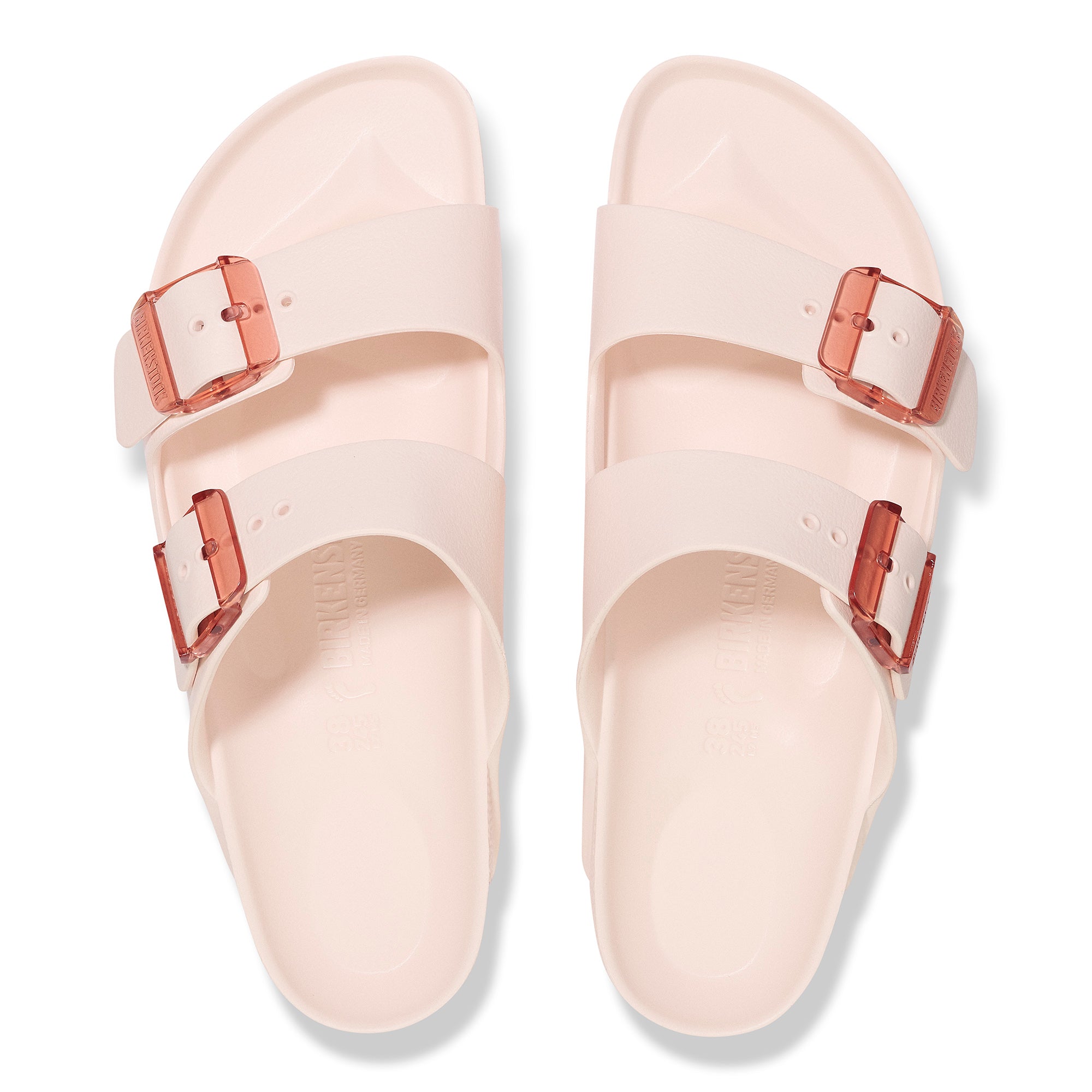 Pair of light pink sandals with rose gold buckles on a white background