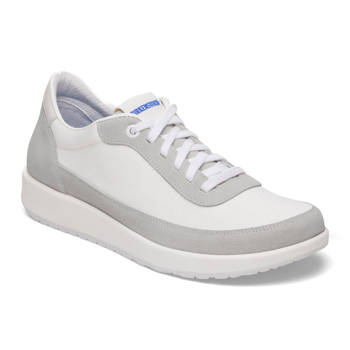 A white and light gray low-top sneaker with white laces, a thick white sole, and a blue brand tag on the tongue, shown on a clean white background.