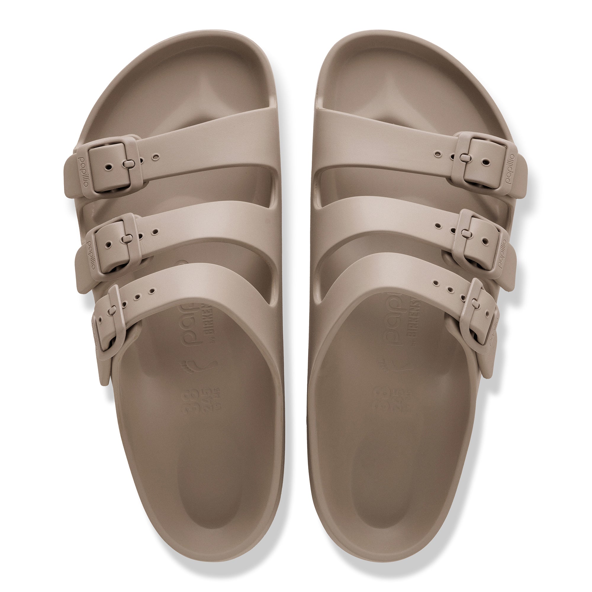 Pair of beige sandals with multiple straps on a white background
