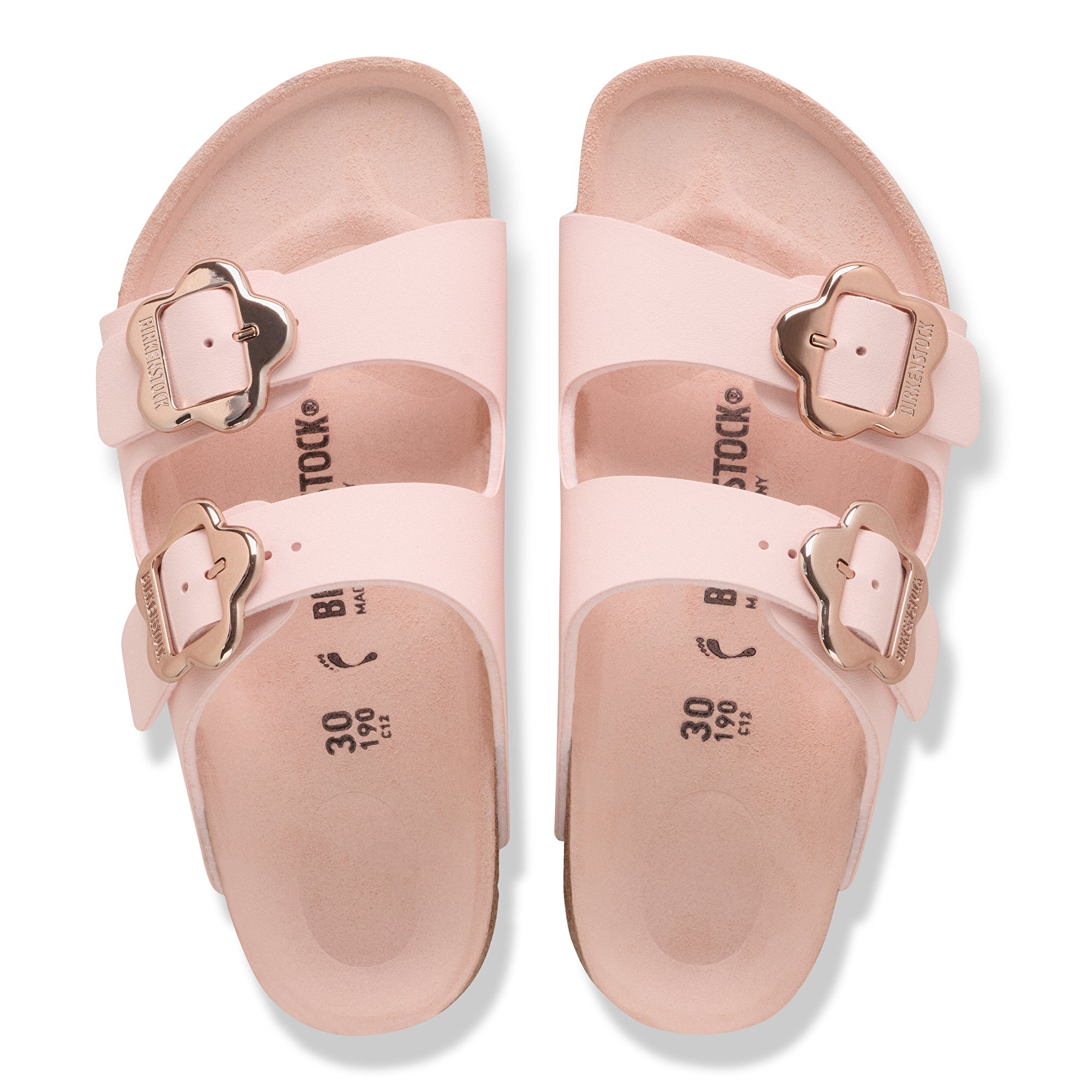 Pair of pink sandals with gold buckles on a white background