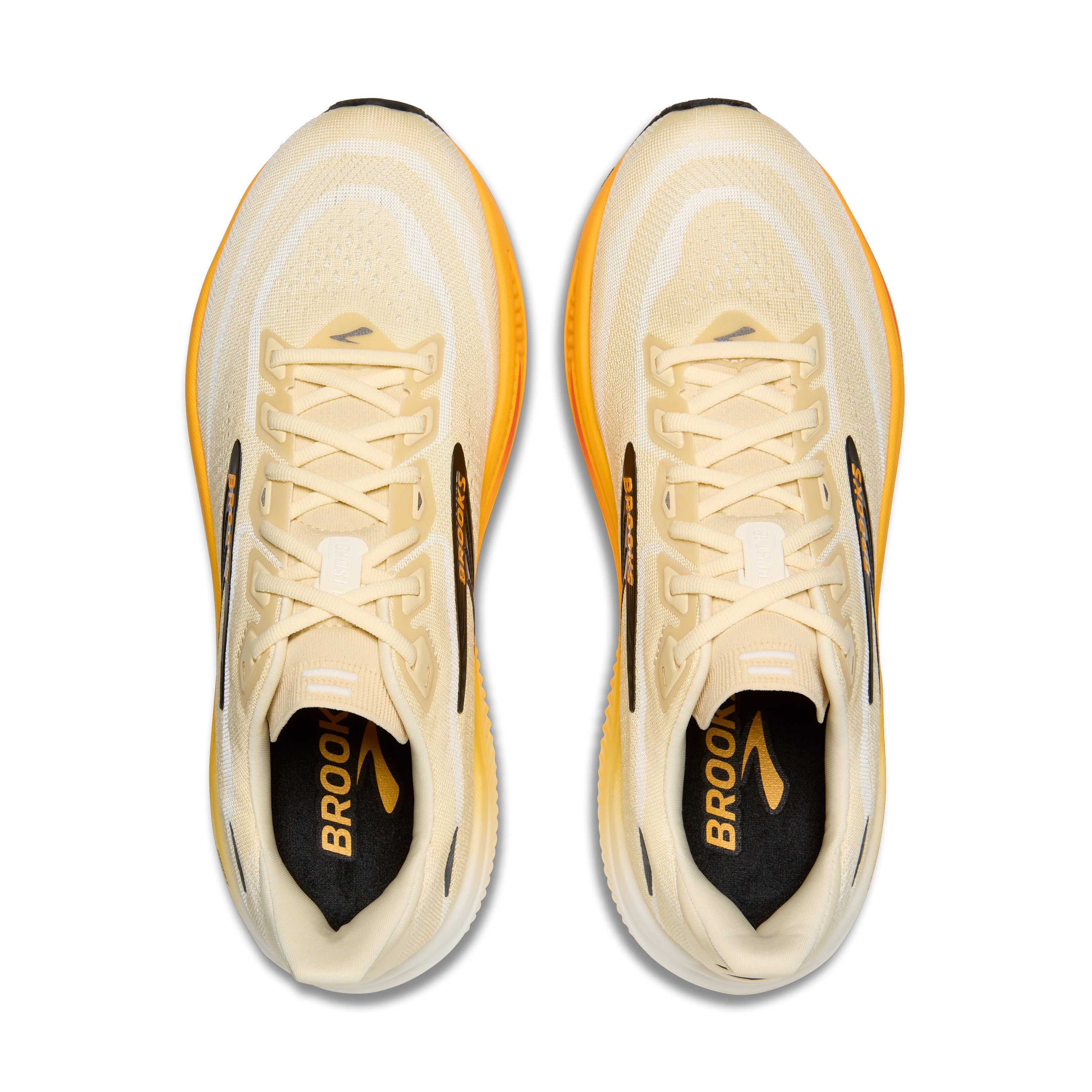Pair of beige running shoes with orange accents on a white background
