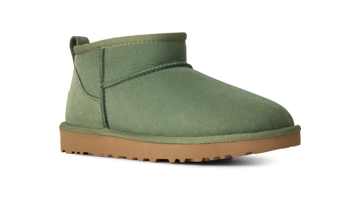 An olive green suede ankle boot with a tan rubber sole, shown from a side profile on a white background.