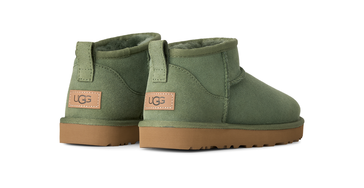 A pair of UGG Mini boots in olive green suede with tan rubber soles and a brown UGG logo patch on the heel.