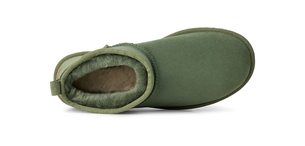 An olive green suede ankle boot with a soft, fuzzy fleece lining, shown from a side profile view on a white background.