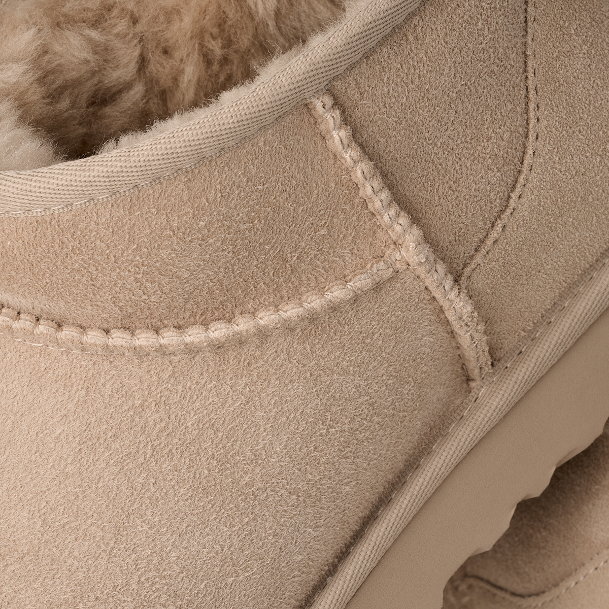 Close-up of a beige suede shoe with stitching detail