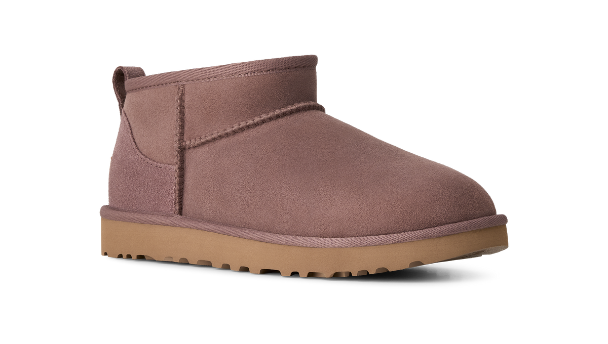A single mid-calf suede bootie in a muted dusty rose-brown color, featuring a tan rubber sole, shown from a side profile on a white background.