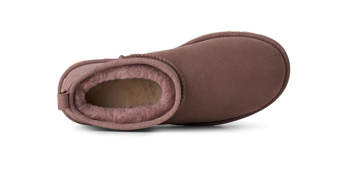 A single brown suede ankle boot with a soft pinkish-brown shearling lining, shown from a side profile view on a white background.