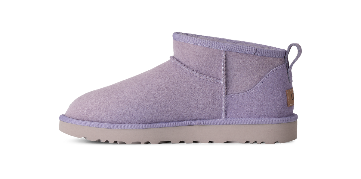 A single light purple suede ankle boot with a matching purple pull tab and a light gray sole, shown in profile against a white background.