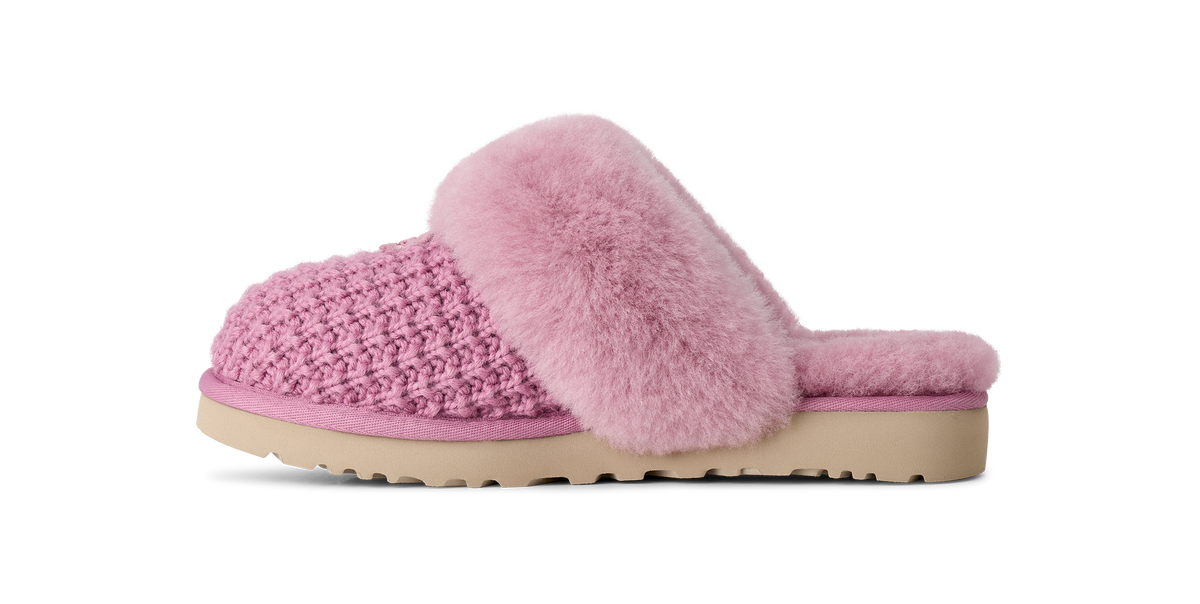 A pink knit slip-on mule slipper with a fluffy faux-fur trim and a beige sole, shown in profile against a white background.