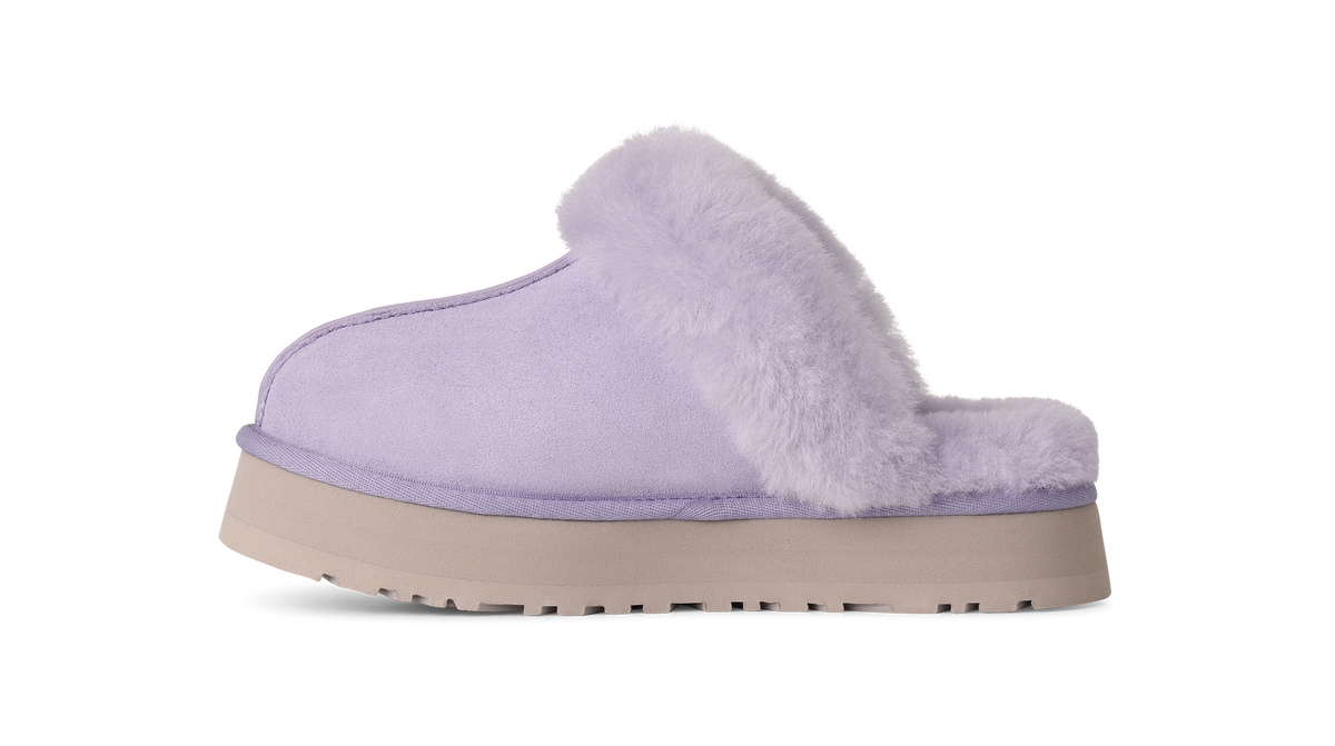 A single light purple slipper with a fluffy faux-fur trim and a beige platform sole, shown from the side on a white background.