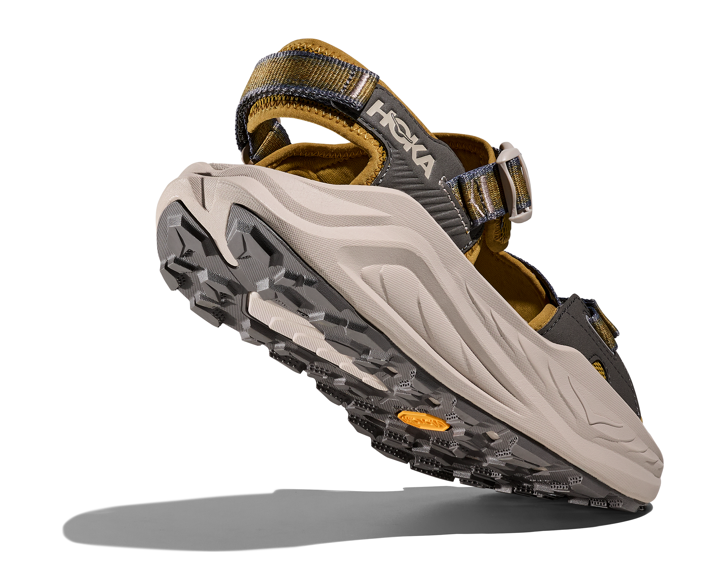 Hoka sandal with beige sole and brown straps on a white background