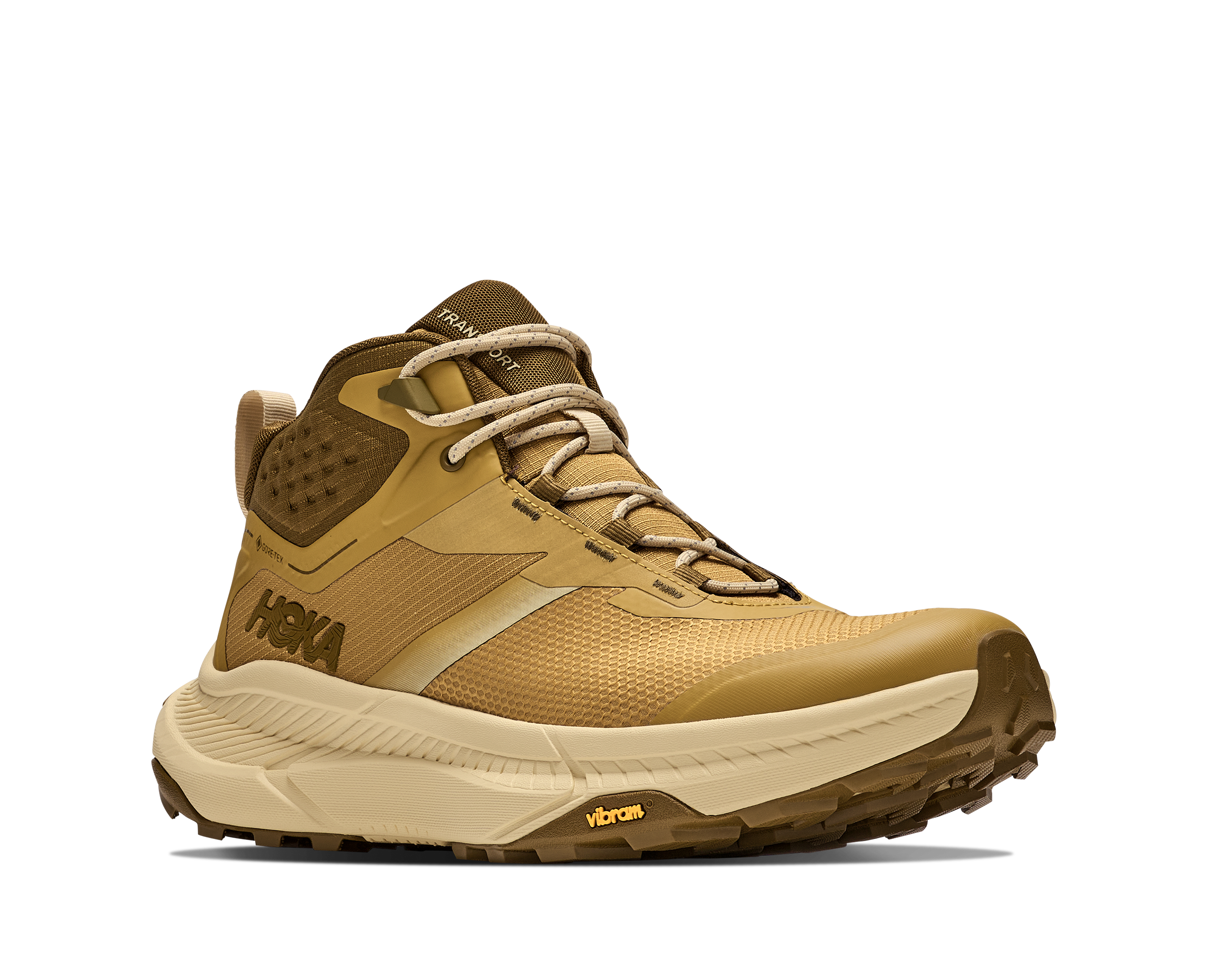 A Hoka mid-top hiking boot in tan and brown, featuring a textured mesh upper, tan laces, and a thick beige and brown Vibram sole, shown from a side profile on a white background.