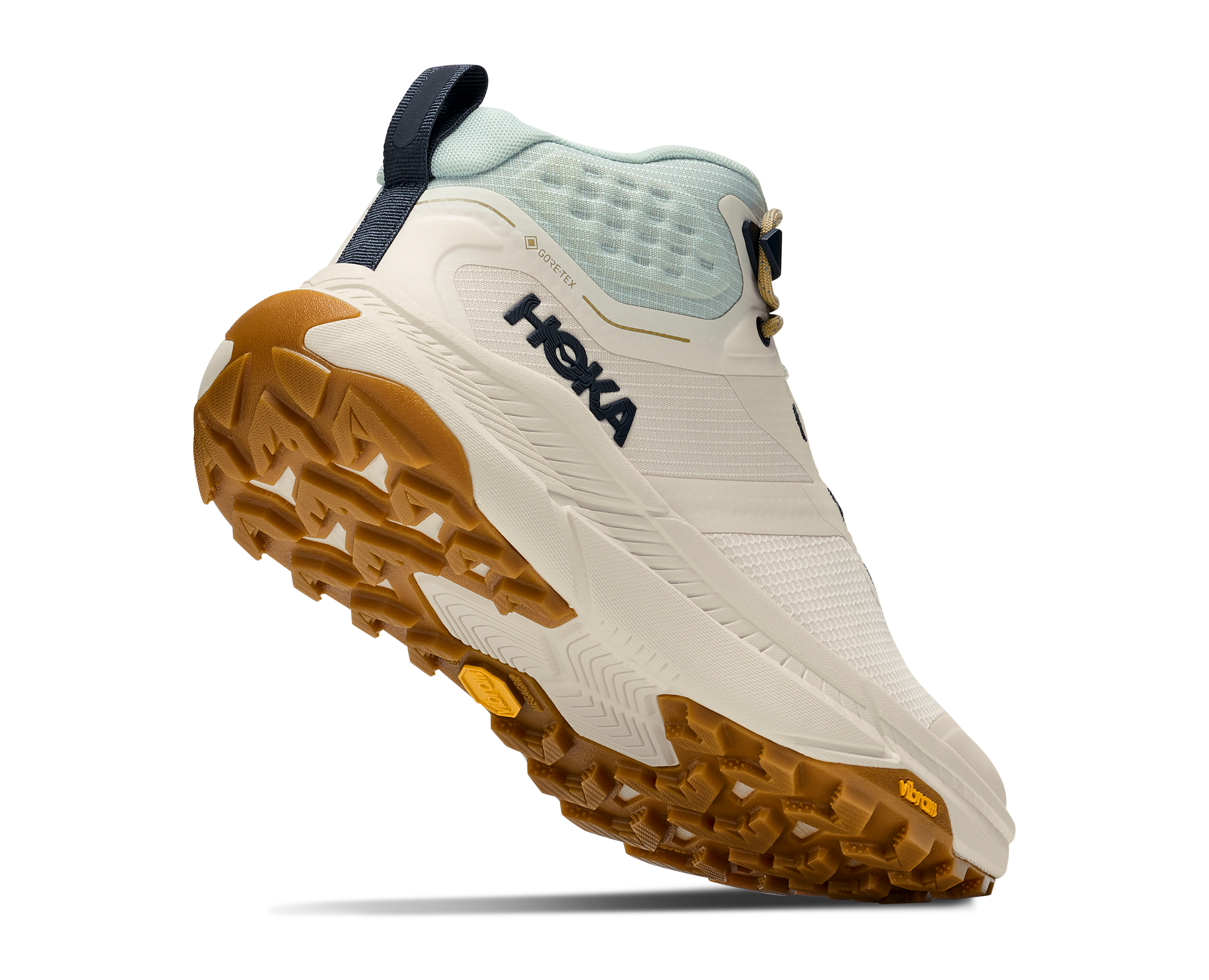 A HOKA outdoor hiking boot shown from a three-quarters angle, featuring a cream and light blue upper with a rugged brown gum sole.