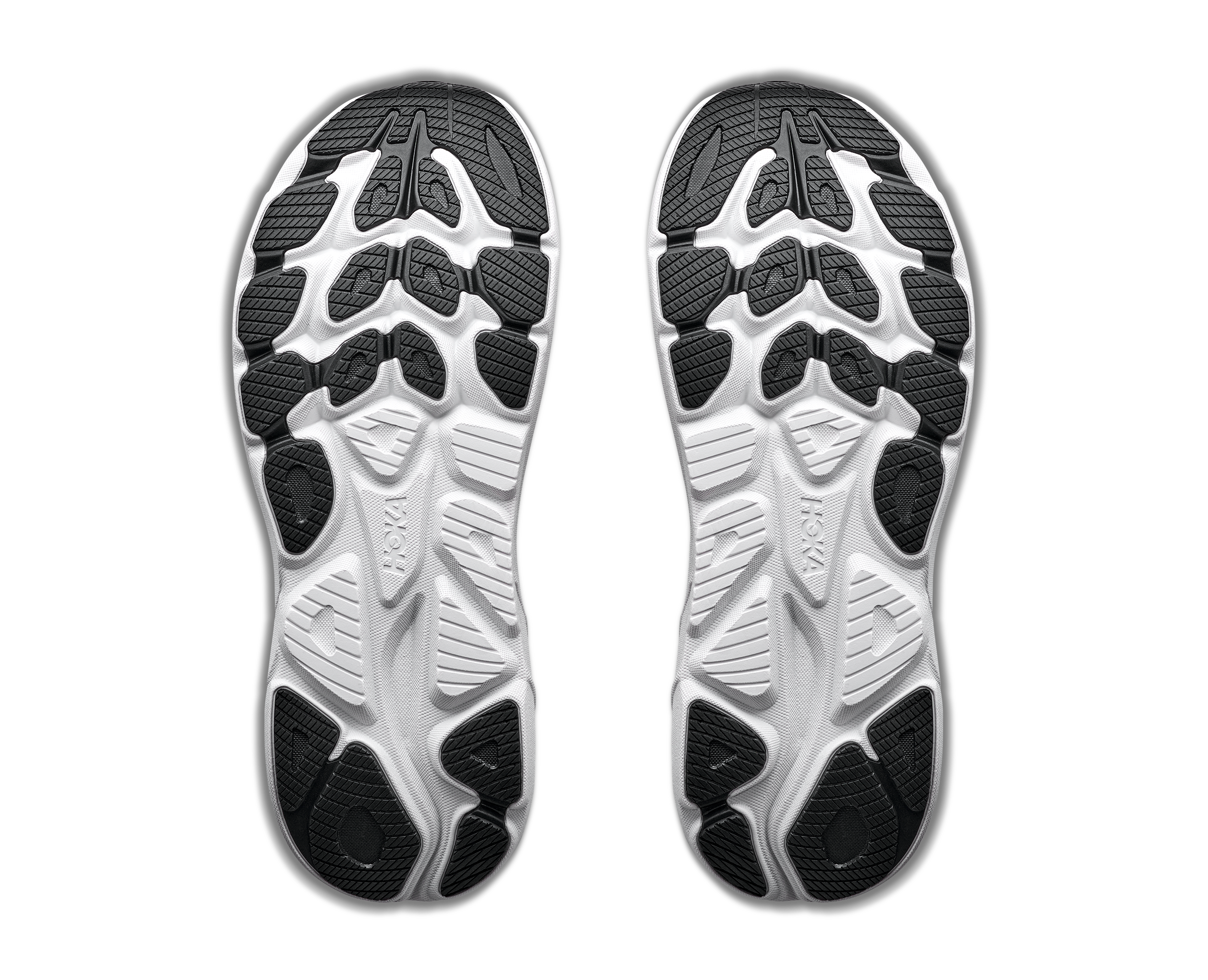 Close-up of a pair of black and white athletic shoe soles on a white background
