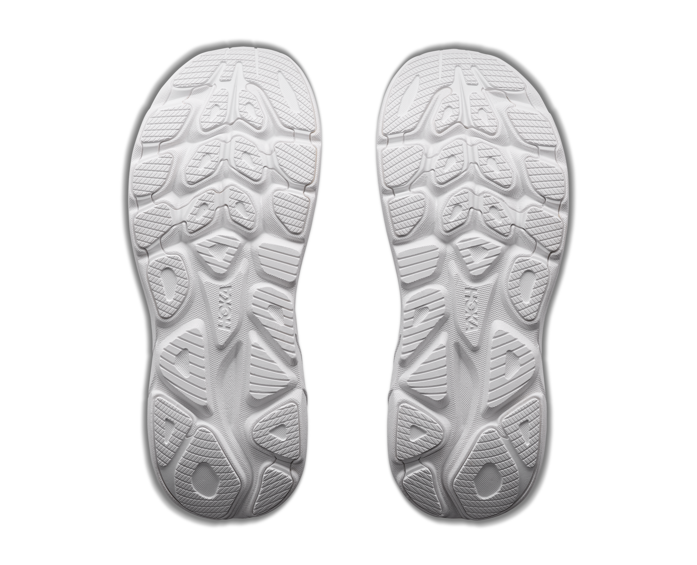 White shoe soles with tread pattern on a black background