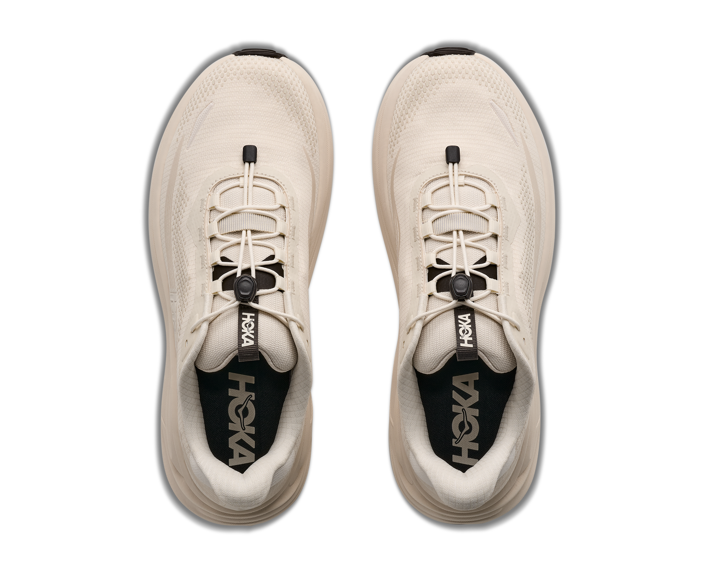 Beige running shoes with black soles on a white background