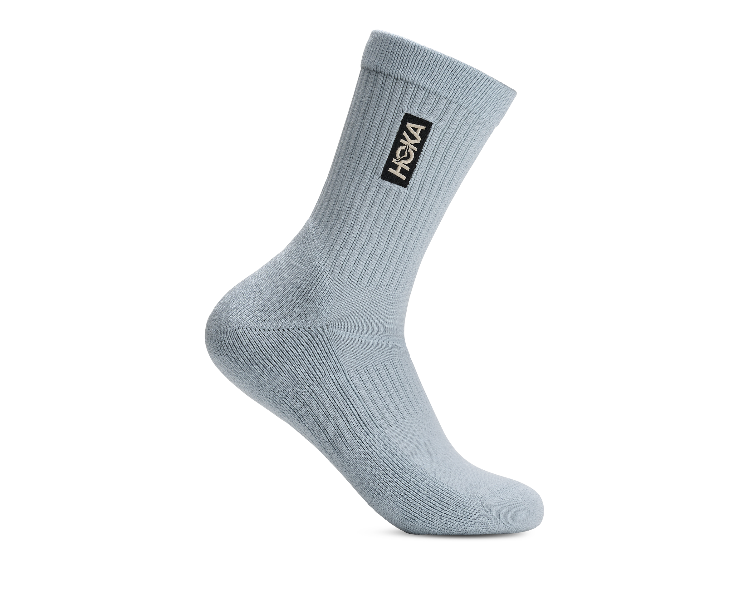 A single light blue-gray ribbed crew sock with a black HOKA logo patch on the cuff, shown on a plain white background.
