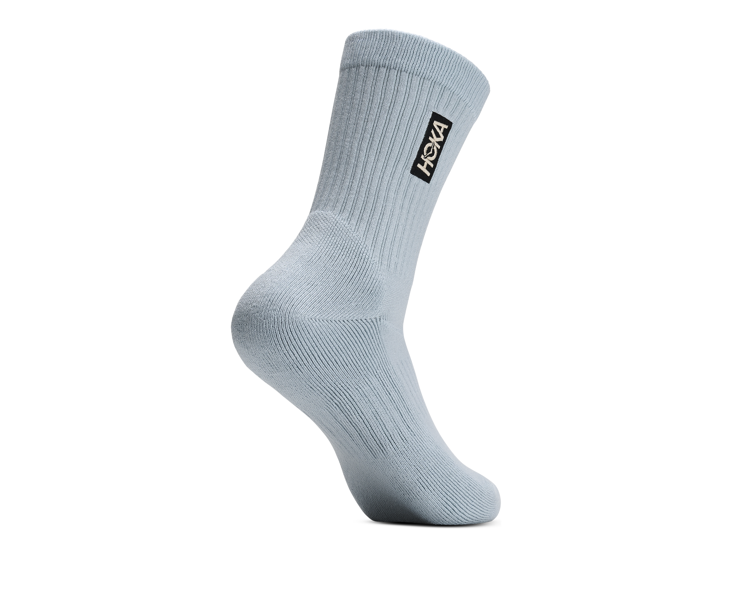 A single light blue-gray crew sock with a black HOKA logo patch on the cuff, shown on a plain white background.