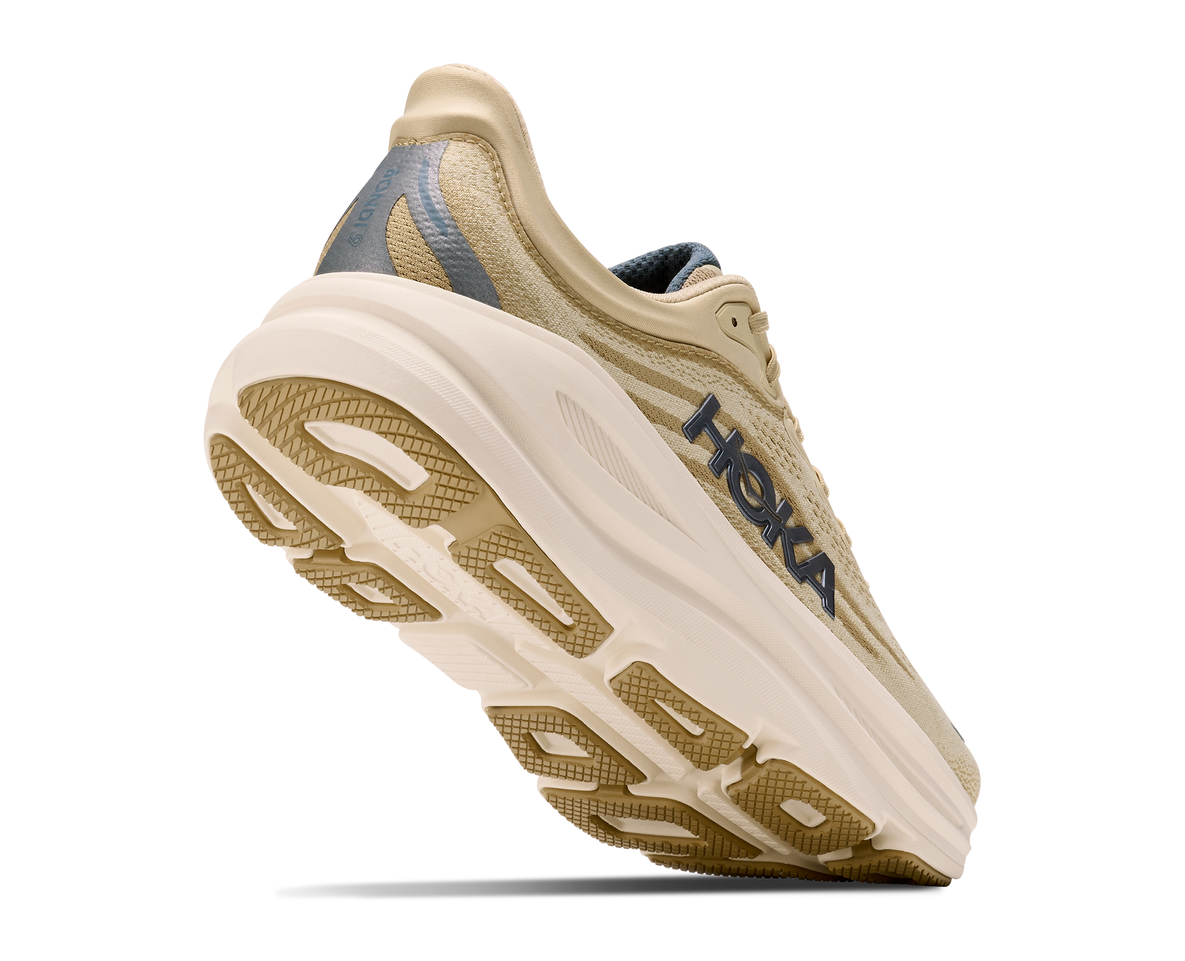 A Hoka running shoe in beige and off-white with a dark navy logo and heel accent, shown from a three-quarters angle against a white background.