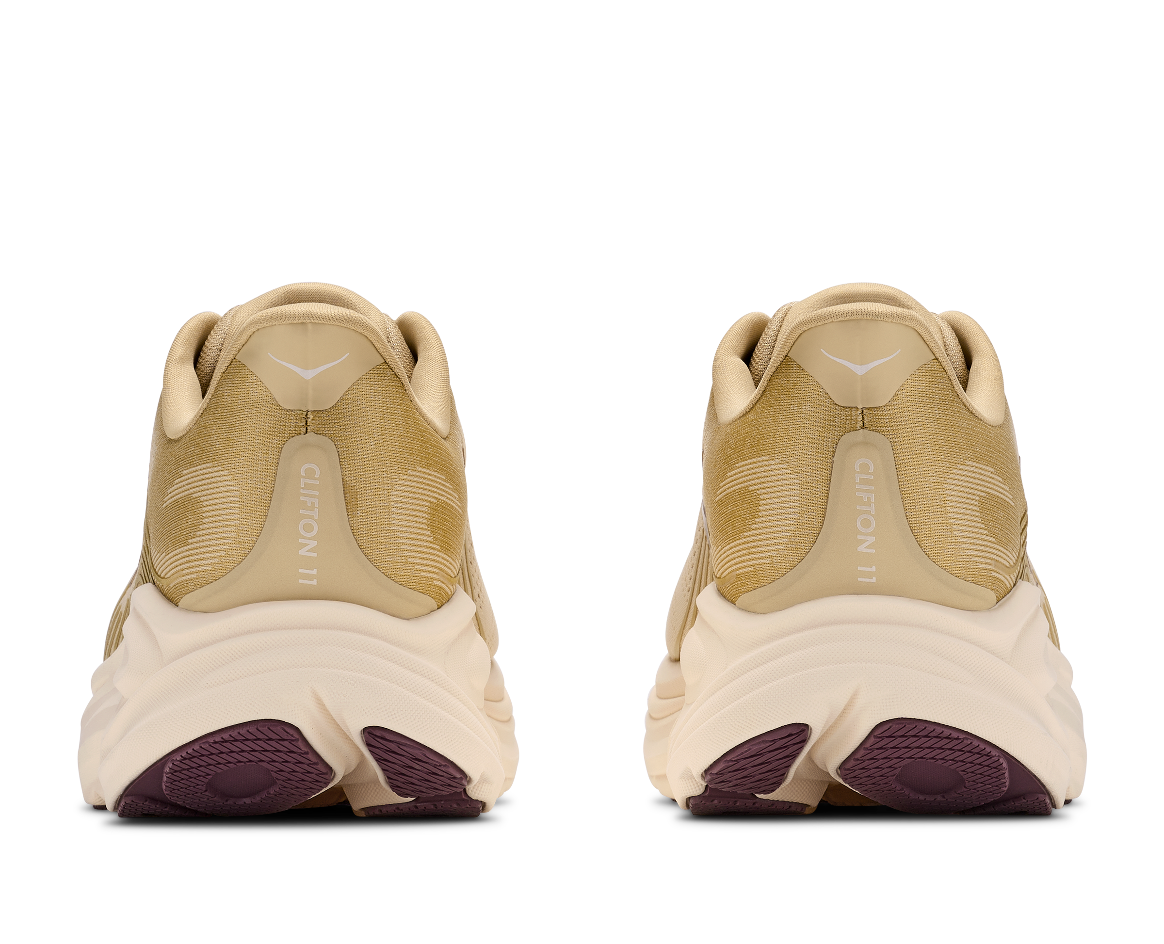 Pair of beige sneakers with purple soles on a white background
