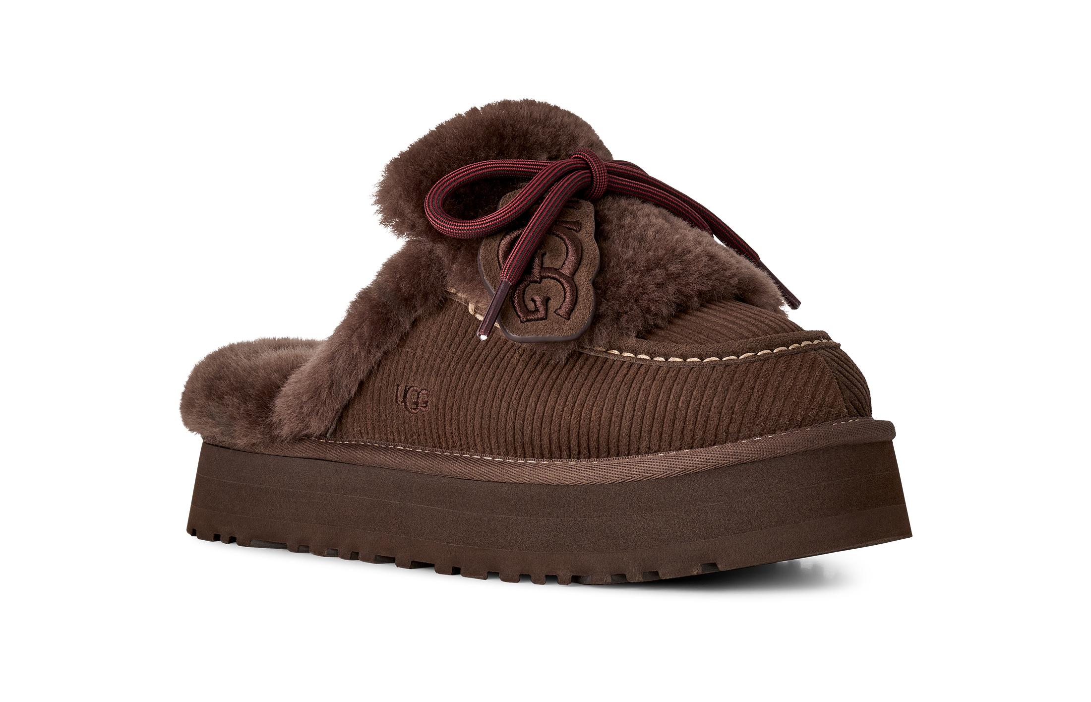 Brown fuzzy slippers with a bow on a white background