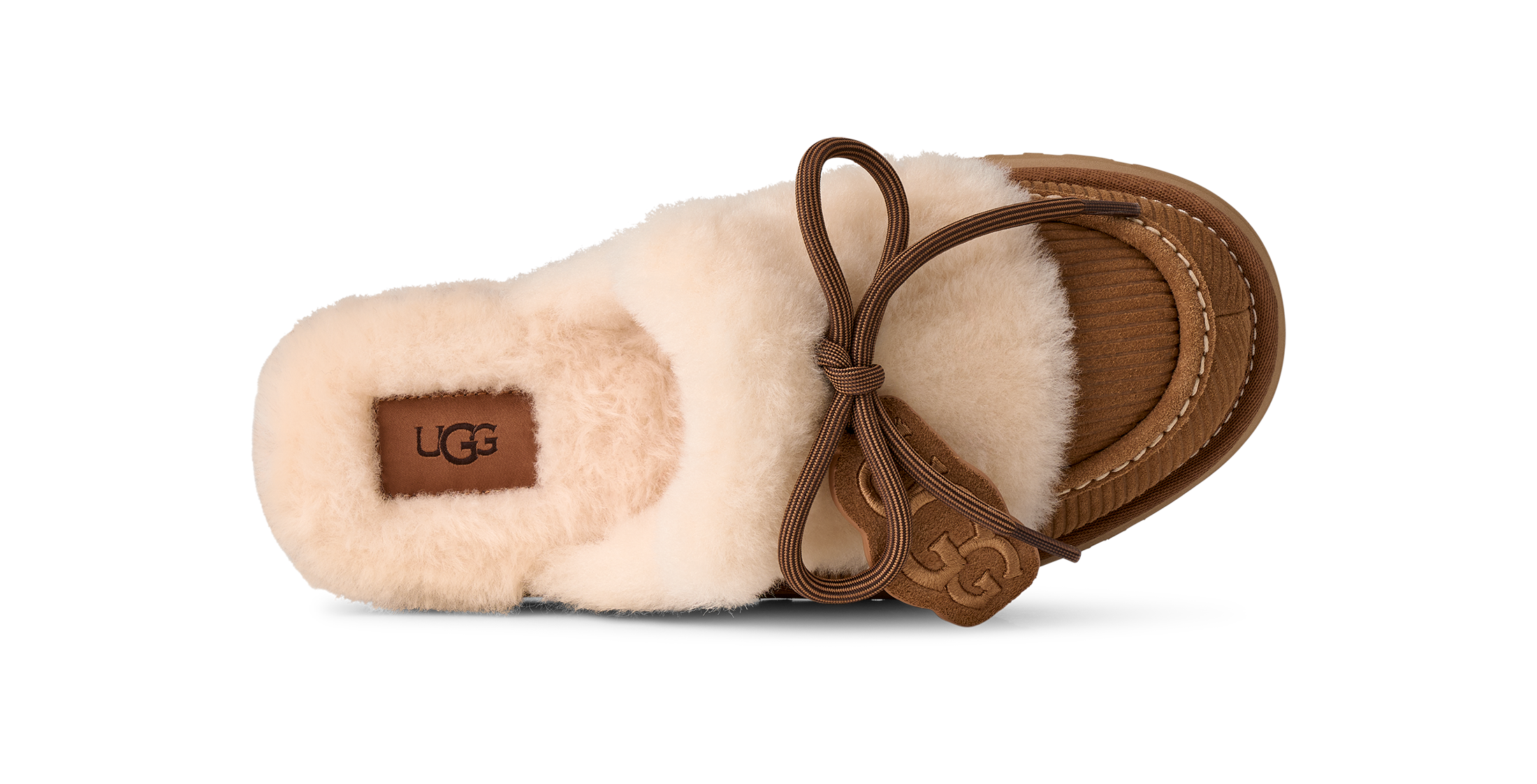 A single UGG slipper in cream sheepskin with a brown leather sole, trim, and bow, shown from a side profile on a white background.