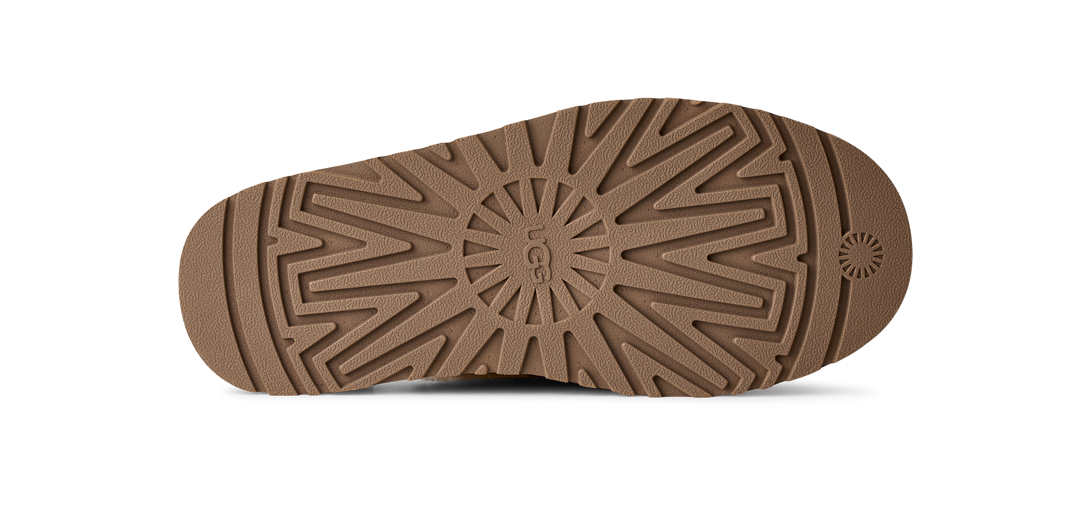 The outsole of a brown shoe, showing a detailed tread pattern and a circular logo embossed in the center, photographed on a white background.