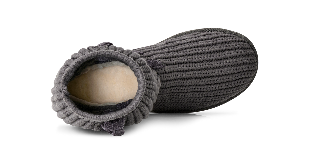 A single dark gray ribbed knit slipper boot with a cream-colored plush lining, shown from an angled top-down view on a white background.