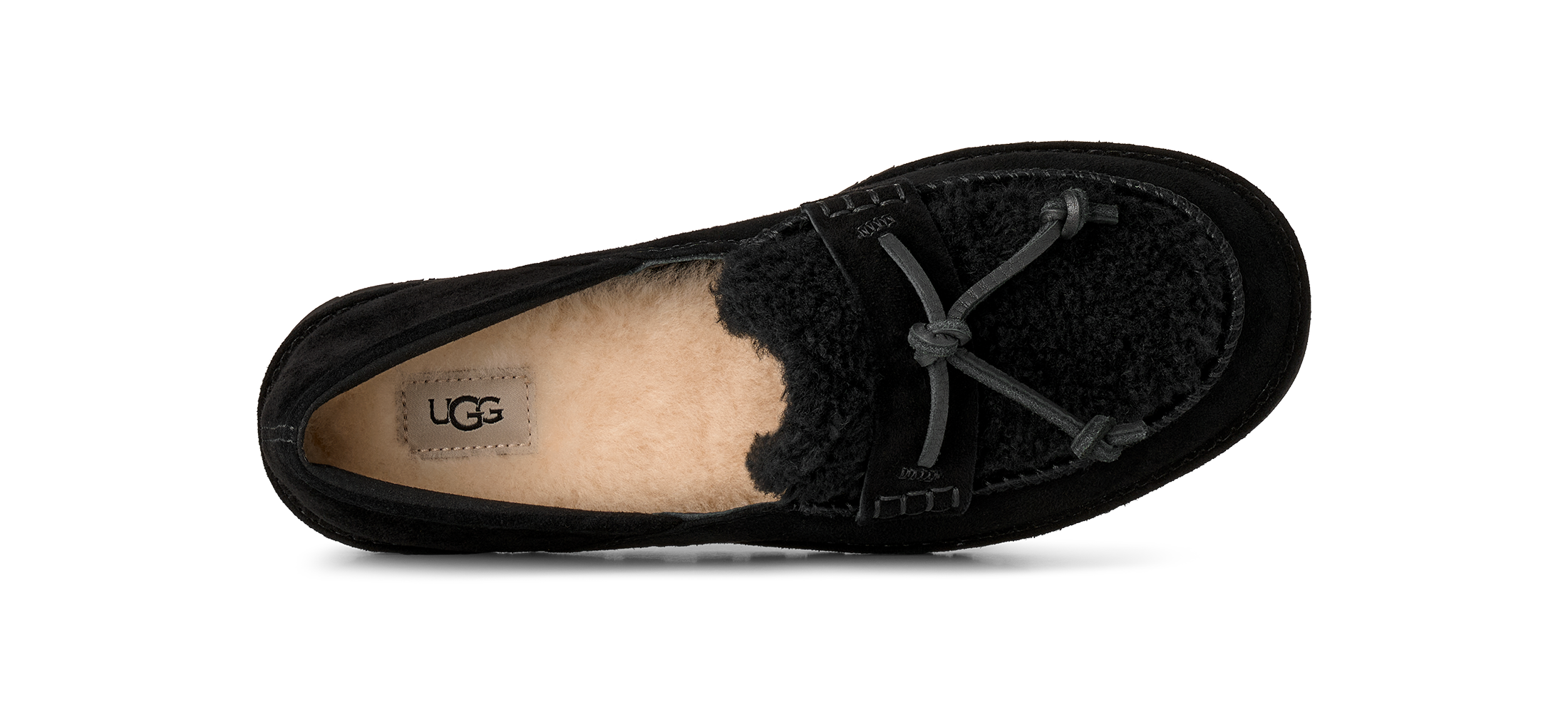 A single black UGG slip-on shoe with a black suede upper, black fuzzy shearling lining, and a gray tie detail on the toe, shown from a side profile view against a white background.