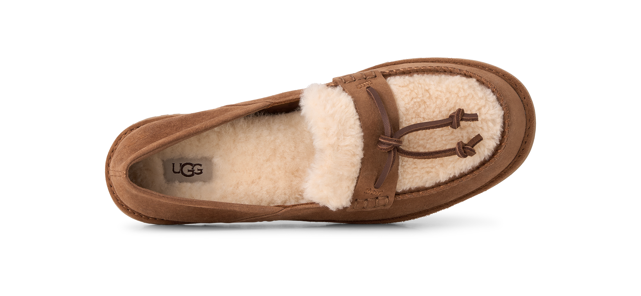 A single brown suede UGG slipper with a cream shearling lining and a brown leather tassel detail, shown from a top-down view on a white background.