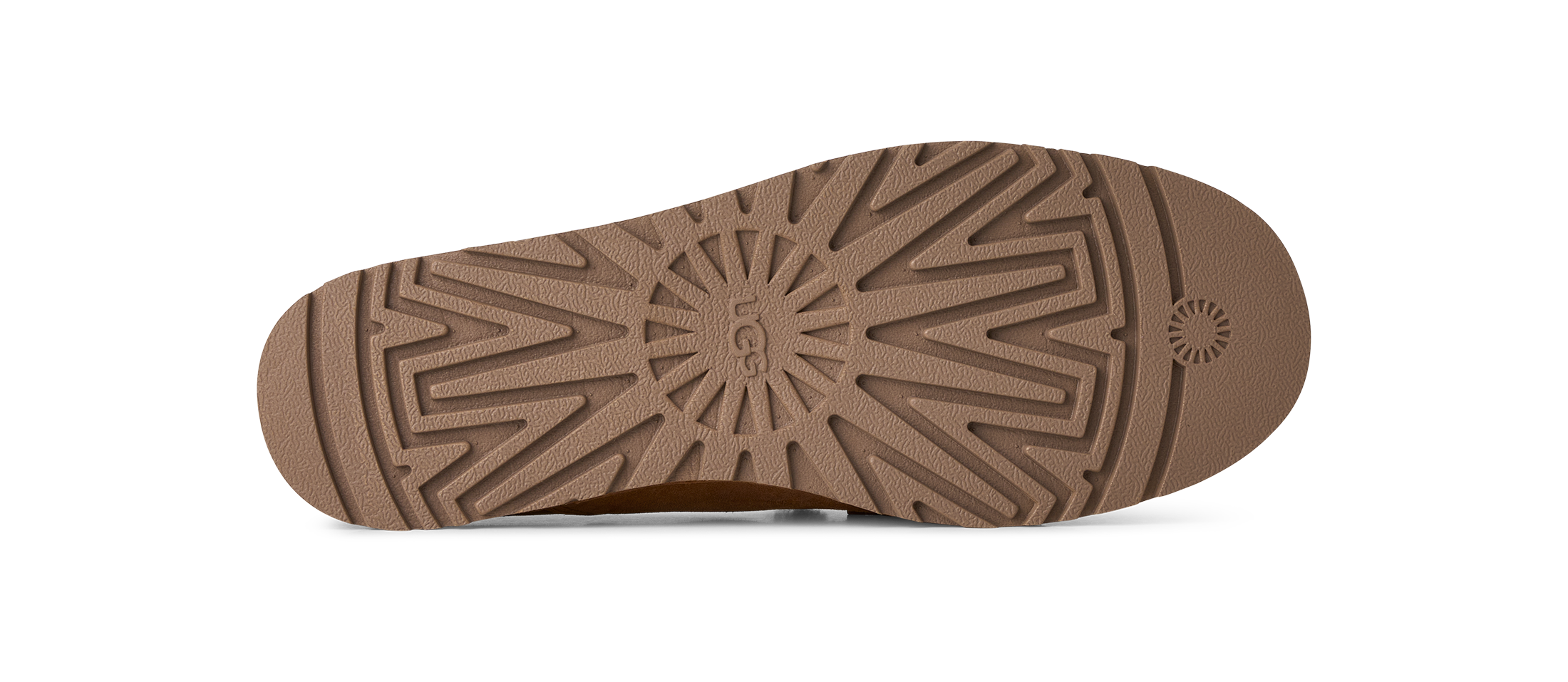 The brown rubber outsole of a shoe, showing the tread pattern and embossed UGG logo, photographed from a top-down view on a white background.