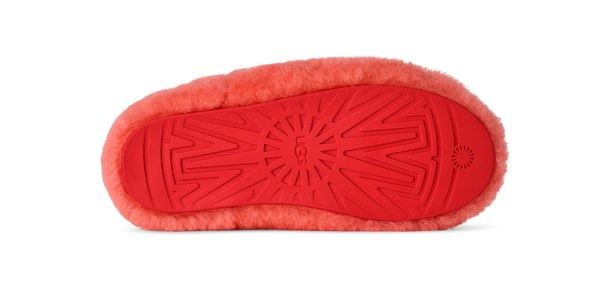 Red slipper with textured sole on a white background